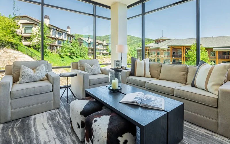 Sunlit lounge with floor-to-ceiling windows at Ski Ya Later, a Park City ski-in/ski-out condo in Canyons Village.