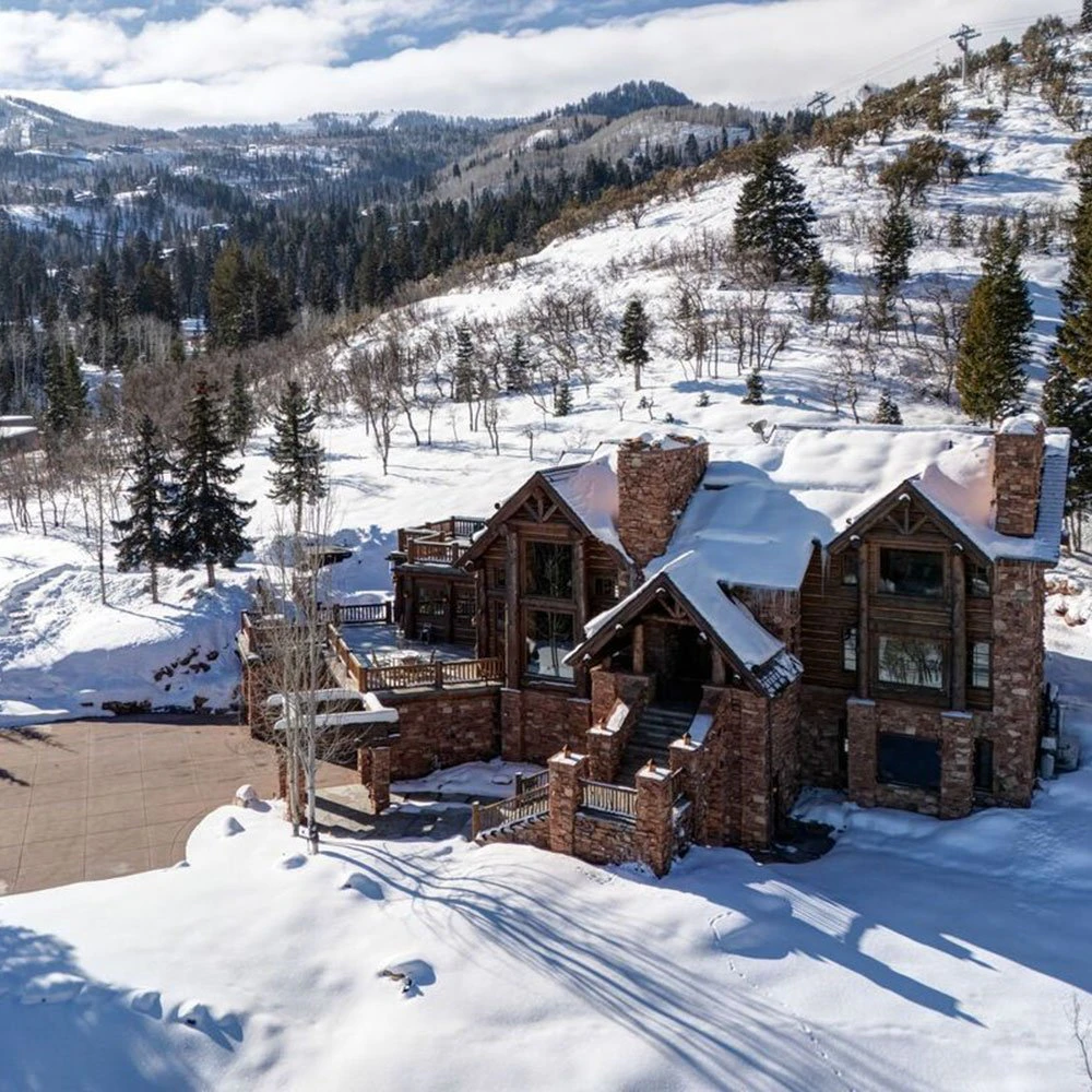 park-city-ski-in-ski-out-intro-image-the-treehouse Aerial winter view of a luxury Park City ski-in/ski-out lodge nestled beside groomed trails and snow-covered trees.