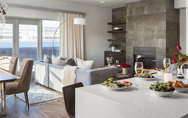 Interior of The Glenwood, a stylish Jackson Hole condo featuring a modern open-plan kitchen and living area with fireplace, ideal for luxury mountain living.
