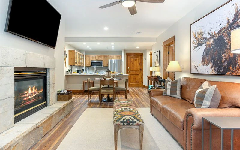 Open-plan living area at Pinecone Lodge in Arrowhead Village, Beaver Creek, with fireplace, full kitchen, and modern mountain décor – perfect for a cosy Beaver Creek condo retreat.