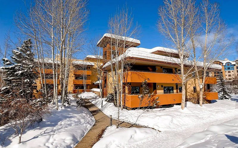 Canyon Creek Condos with heated paths and bright orange lodge-style buildings, ideal for family-friendly Steamboat Springs Condos