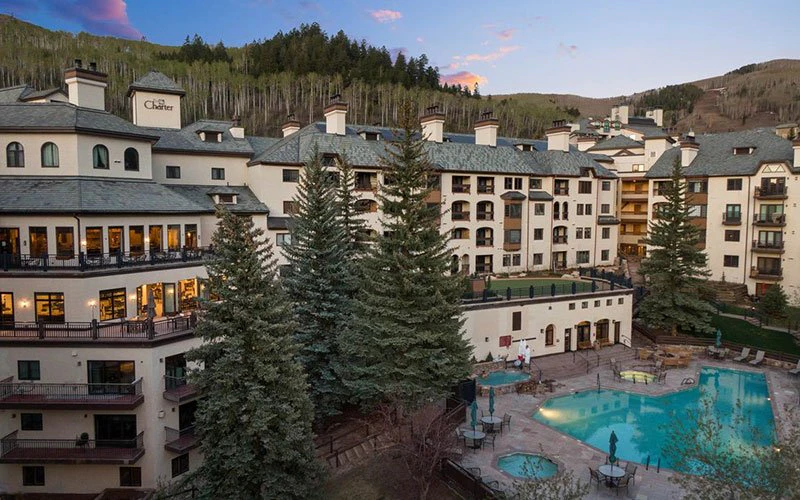 Evening view of The Charter in Beaver Creek Village, a full-service Beaver Creek condo with outdoor pool, spa, and easy access to shops and ski lifts.