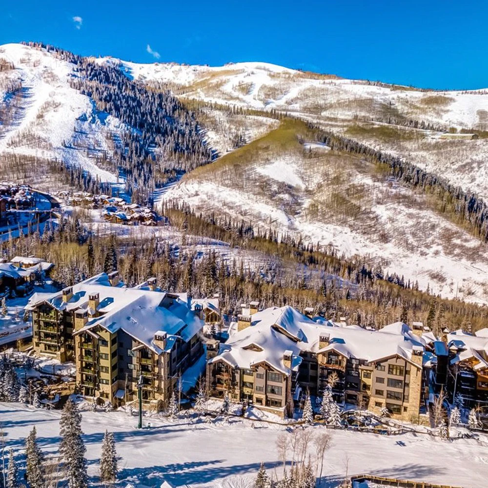 Panoramic view of Deer Valley Condos nestled in the mountains with snowy terrain, illustrating the best condo stays in Deer Valley across Empire Pass, Silver Lake, and Snow Park.