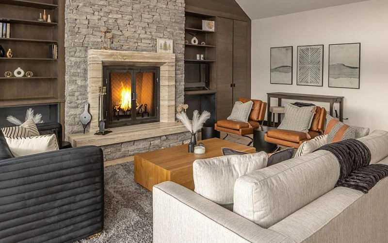 Stylish interior of Moose Ridge Condos, showcasing vaulted ceilings and fireplace within a warm, inviting Big Sky Condos setting.