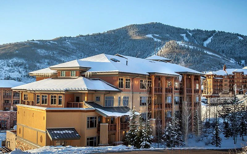 Snow-covered exterior of Sundial Lodge in Canyons Village, showcasing ski-in/ski-out access and premium Park City Condos views.