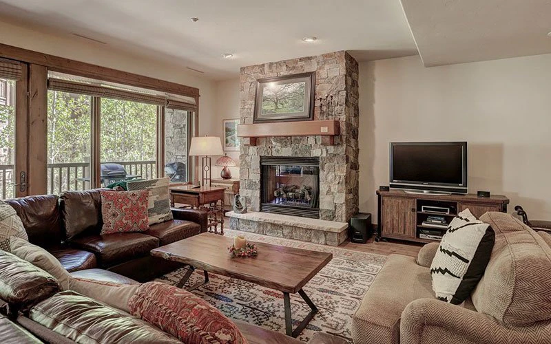 Spacious living room with stone fireplace at One Arrowhead Place, a family-friendly Beaver Creek condo in Arrowhead Village with vaulted ceilings and resort access.