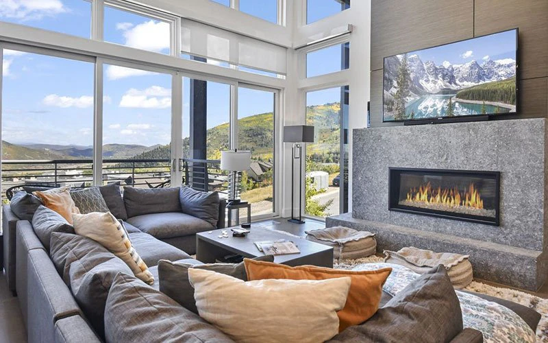 Bright, panoramic living space with fireplace at Apex Residences, a high-elevation Park City Condos property in Canyons Village.