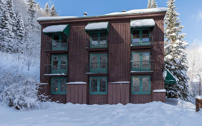 Manitou Lodge Telluride condos set in the snow with rustic architecture and close proximity to ski lifts and the San Miguel River.