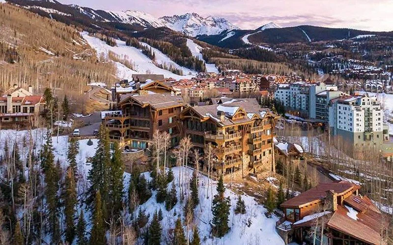 See Forever San Sophia Telluride Vacation Rentals aerial view of luxury mountain lodge surrounded by snowy peaks and village scenery.